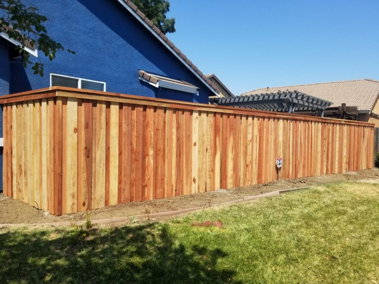 wooden garden fence against a blue house
